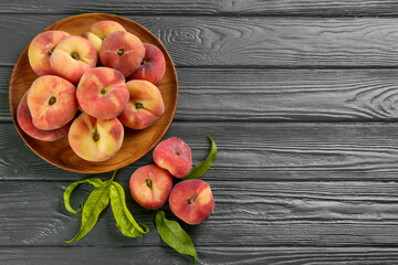 Fresh ripe donut peaches on grey wooden table, flat lay. Space for text