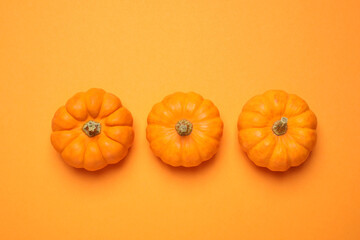 Fresh ripe pumpkins on orange background, flat lay