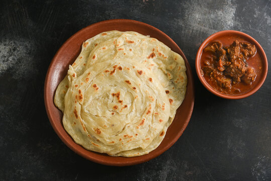 Kerala paratha porotta meat curry roti Malabar parotta barotta is Indian layered flatbread for breakfast or snack, popular street food in India. Maida or wheat flour Cooking the dough. 