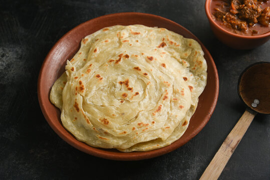 Kerala paratha porotta meat curry roti Malabar parotta barotta is Indian layered flatbread for breakfast or snack, popular street food in India. Maida or wheat flour Cooking the dough. 