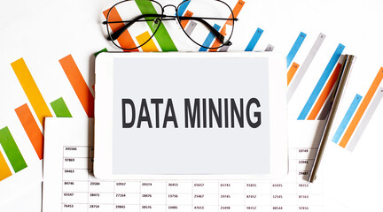 The tablet with DATA MINING on a chart with pen and glasses