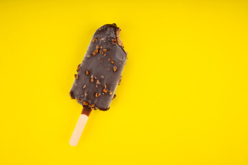 ice cream stick  chocolate and almonds  on yellow background