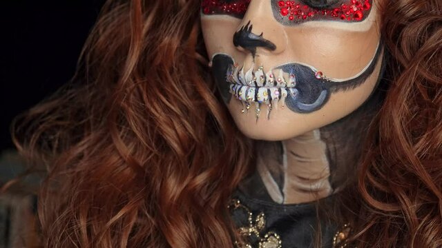 Beautiful Halloween Make-Up Style. Brunette Model Wear Sugar Skull Makeup with Red Roses. Santa Muerte concept