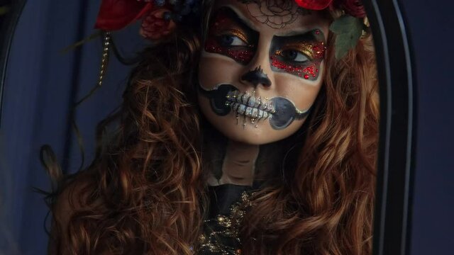 Attractive young woman with sugar skull makeup. Mexican Day of the dead woman wearing sugar skull makeup