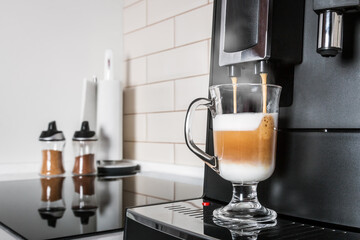 glass of hot cappuccino made in the coffee machine