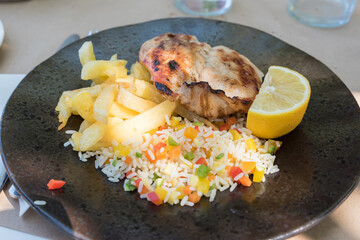 Chicken breast with rice salad and french fries