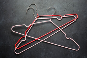 Red coat hangers on a dark concrete background. Copy space