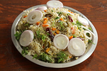 Indian vegetable biryani served in a plate on Wood background