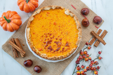 slice of home made pumpkin pie on plate with pumpkins