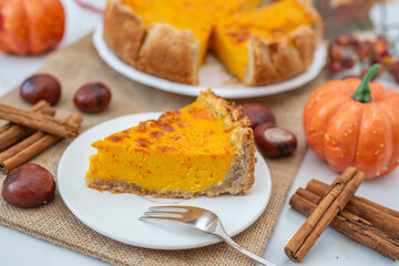 slice of home made pumpkin pie on plate with pumpkins