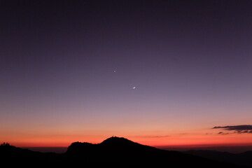 sunset over the mountains and the moon with star