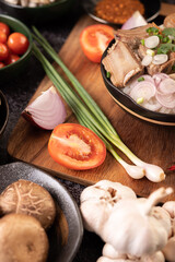 Scallions, peppers, garlic, and shiitake mushrooms on a wooden plate