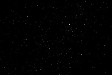 Stars on a dark night sky. Blurred, defocus. Abstract background