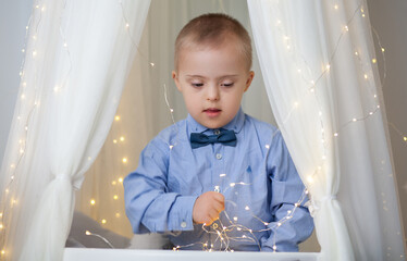 Little cute boy with bright birthday lights, new year 2021 and christmas, new year tree with...