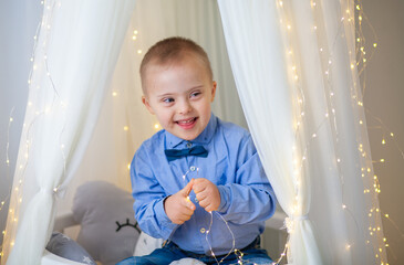 Little cute boy with bright birthday lights, new year 2021 and christmas, new year tree with...