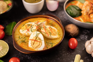 Egg green curry in black cups.
