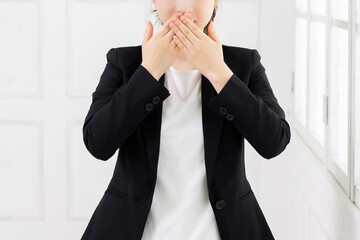 口を隠す若いビジネスウーマン