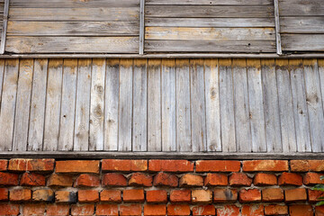 Fototapeta premium Wall of an old building- red bricks on the bottom and wooden planks on top