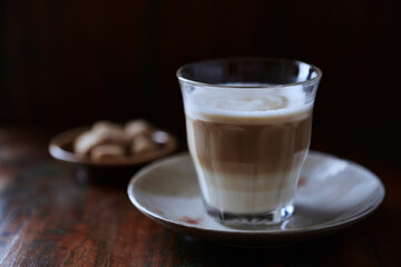 Glass of Latte Macchiato. Rustic wooden background. Close up. 