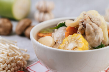 Chicken soup with corn, shiitake mushroom, enoki mushroom, and carrot.