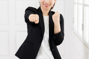 パンチのジェスチャーをする若いビジネスウーマン