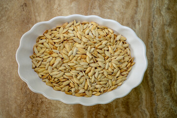 Dried pumpkin seeds roasted and lightly salted in a bow.