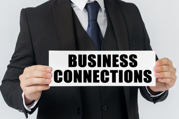 A businessman holds a sign in his hands which says - BUSINESS CONNECTIONS