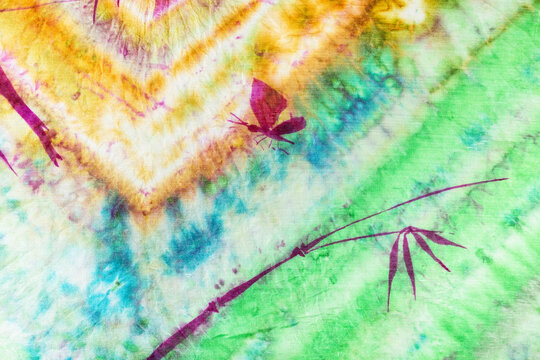 textile background - part of colorful colored batik silk scarf with hand-drawn bamboo twig and butterfly