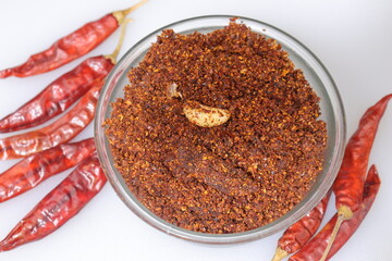 Dry hot red chillies powder on white background from top view.