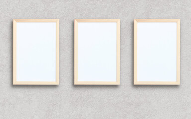 three empty rectangular frames on a gray wall.