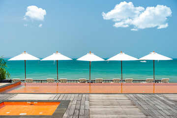 White umbrella and chair with sea view.