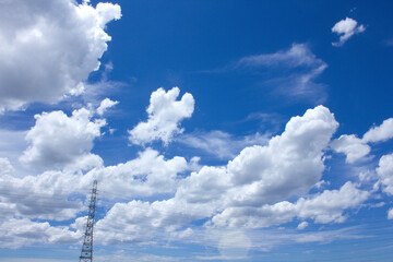 青空と夏の白い雲と送電鉄塔