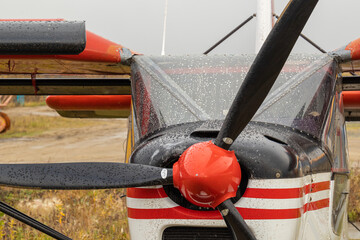 old small civil aircraft parked at the airport in the rain in autumn