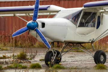 old small civil aircraft parked at the airport in the rain in autumn