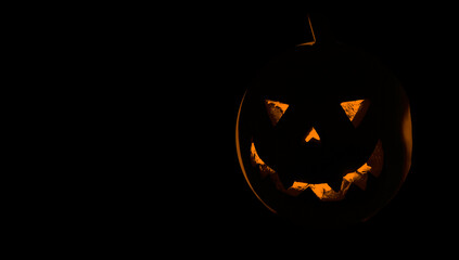 Pumpkin for Halloween glowing demon face in dark.  Scary Halloween pumpkin face 