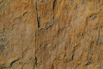 Background from a stone of igneous rock. Wallpaper made of textures of boulders of volcanic origin. Surface of granite, diabase, gabbro interspersed with spar, quartz. Sea shore. Day. Georgia.