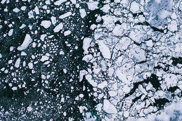 Nature wallpaper of cracked and thawed glaciers ice, floes floating on the water of ocean.