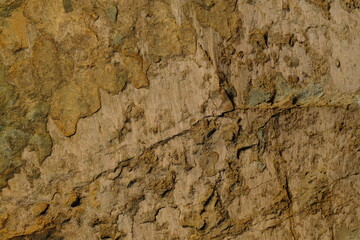 Background from a stone of igneous rock. Wallpaper made of textures of boulders of volcanic origin. Surface of granite, diabase, gabbro interspersed with spar, quartz. Sea shore. Day. Georgia.