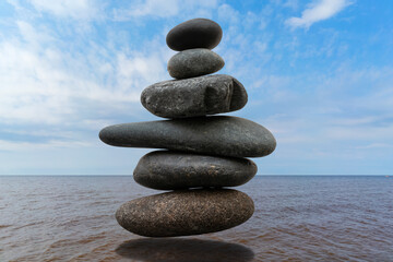 Stack of pebbles in an unstable state. A pyramid made of flat stones.