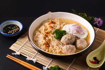 Asian food concept Egg noodles Ramen Asian style with meatball on bamboo matt black background with copy space