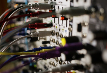 close up of modular synthesizer cables and oscillator sliders