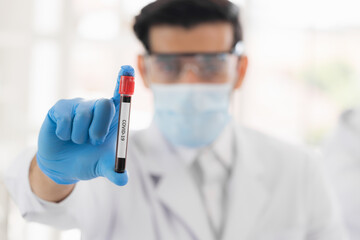 Researchers holding blood tube in life science laboratory. Male research scientist and supervisor preparing and analyzing microscope slides in research lab. Invention of the coronavirus vaccine