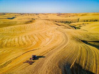 Combine harvester on the yellow hills. Plowed fields, an incredible drawing of the earth. Steptoe Butte State Park, Eastern Washington, in the northwest United States.