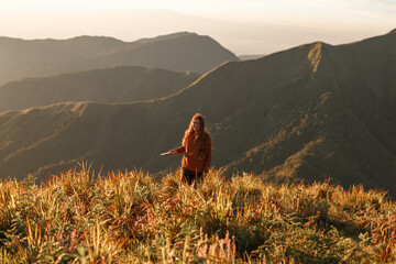 Girl using cellphone with nature scenic in the background, smiling and look athe camera, mountains view