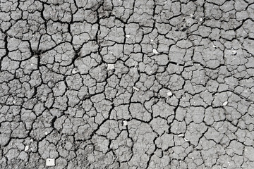 Cracked dry ground gray, on a clear day. Top view.