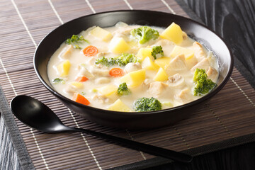 White coloured stew made from béchamel sauce with chicken, carrots, potatoes, onions and mushrooms close-up in a bowl. Horizontal