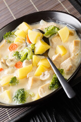 White Cream Stew is a classic Japanese style stew made with chicken, mushrooms, and vegetables close-up in a bowl on the table. Vertical