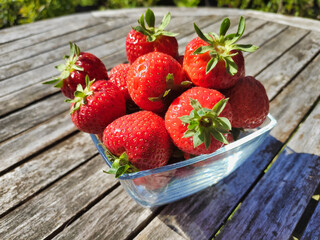 Nahaufnahme von frischen roten Erdbeeren auf rustikalem Holztisch