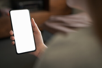 Young woman hold smartphone with white screen while sitting on a couch