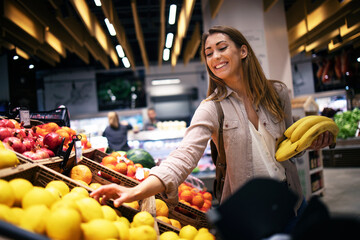 Female buying food at supermarket. Grocery store shopping.